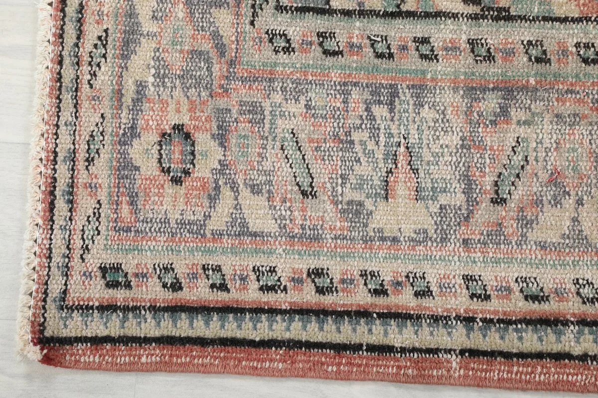 Close-up of the rug's outer border design and color variations