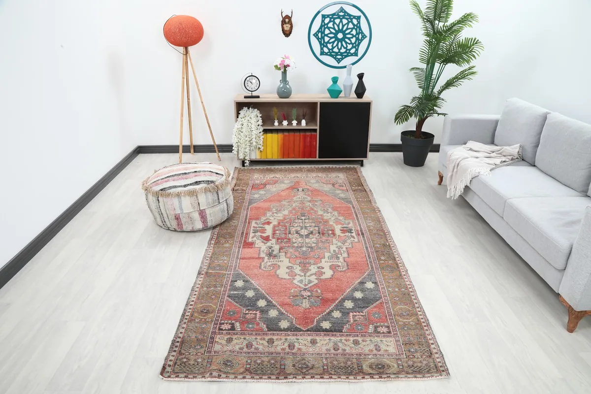 Vintage Anatolian rug displayed in a bright living room setup with a gray sofa and modern decor.