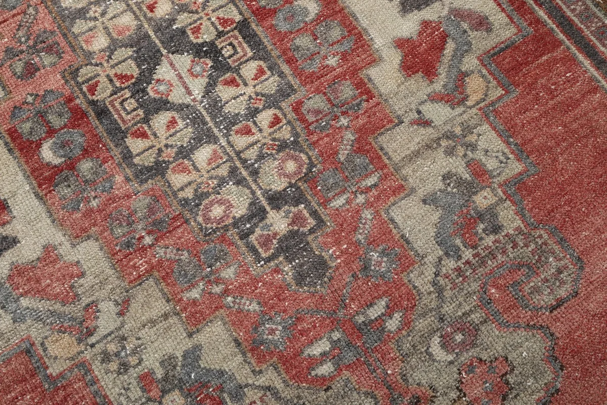 Close-up of the intricate geometric and tribal motifs within the rug's central design.