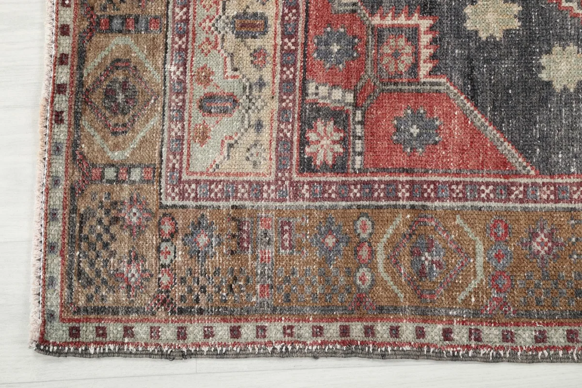 Detailed view of the rug's brown and tan border with its distinct patterns and edge.