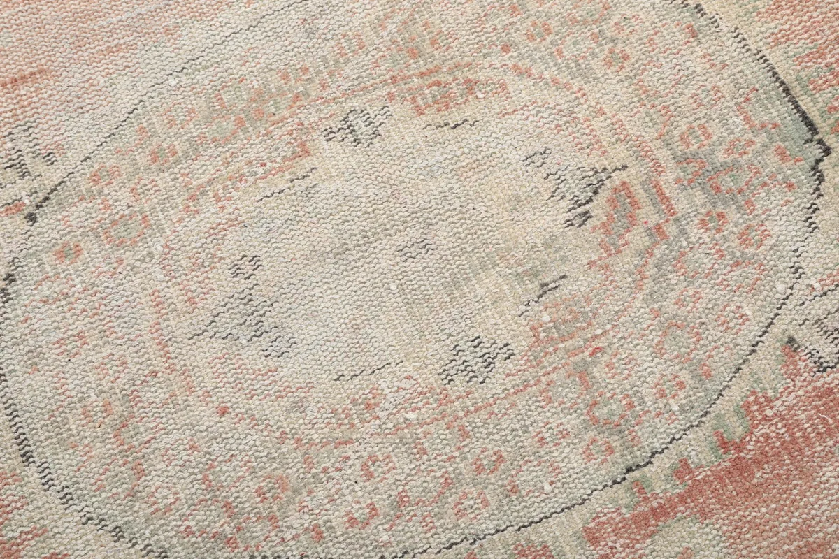 Detailed shot of the faded medallion pattern, showing the intricate hand-knotted wool pile.