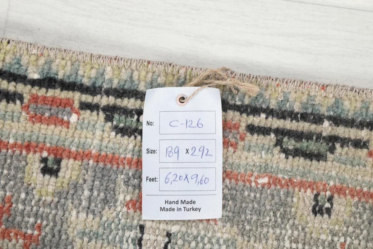 Care tag attached to the rug's reverse, displaying size in centimeters and feet, and confirming hand-made in Turkey.