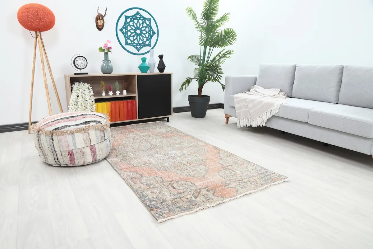 Angled view of the rust and beige tribal medallion rug in a bright, minimalist room.