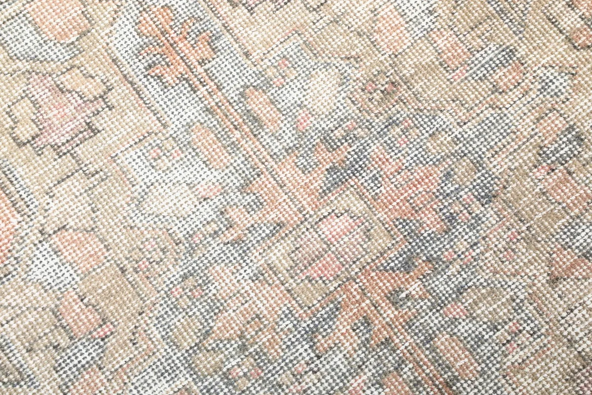Detailed view of the hand-knotted wool pile, showcasing the rust, beige, gray, and blue threads.