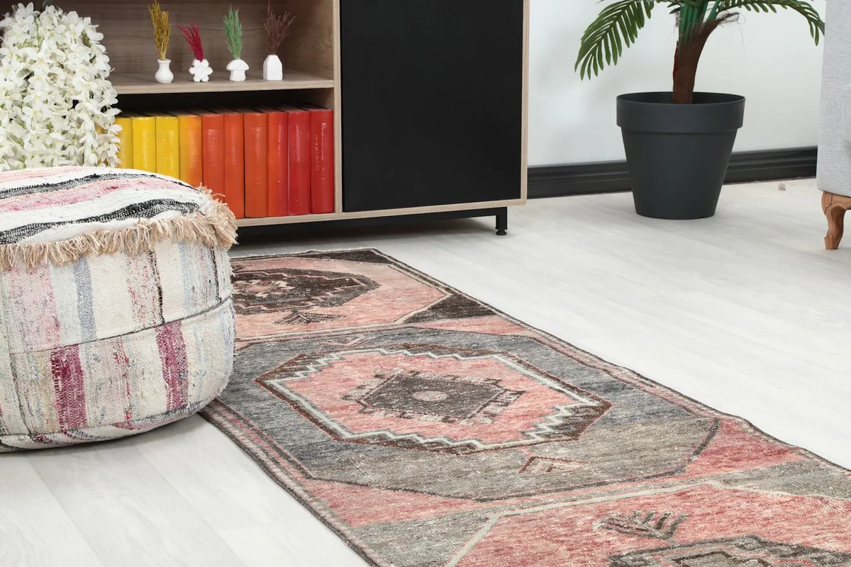Close-up of the runner's design near a decorative ottoman and wooden shelf