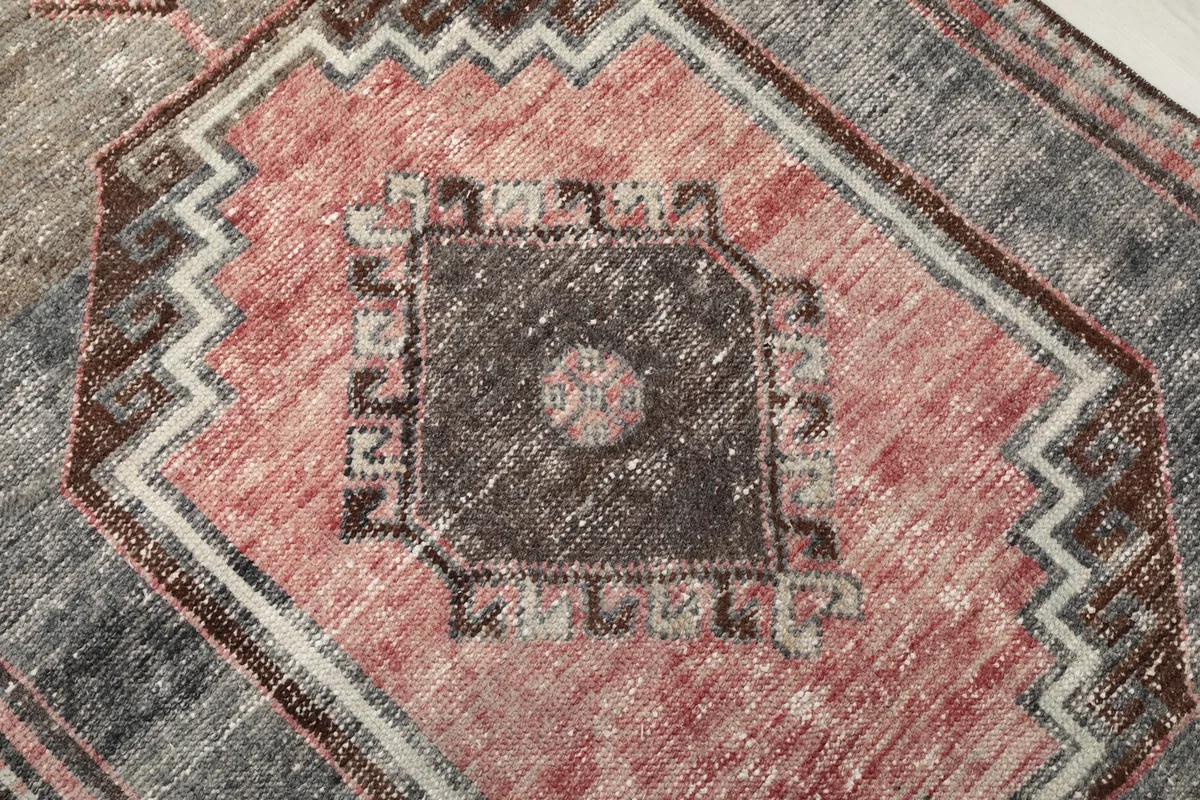 Detailed close-up of the central geometric motif, highlighting wool pile texture and color variations