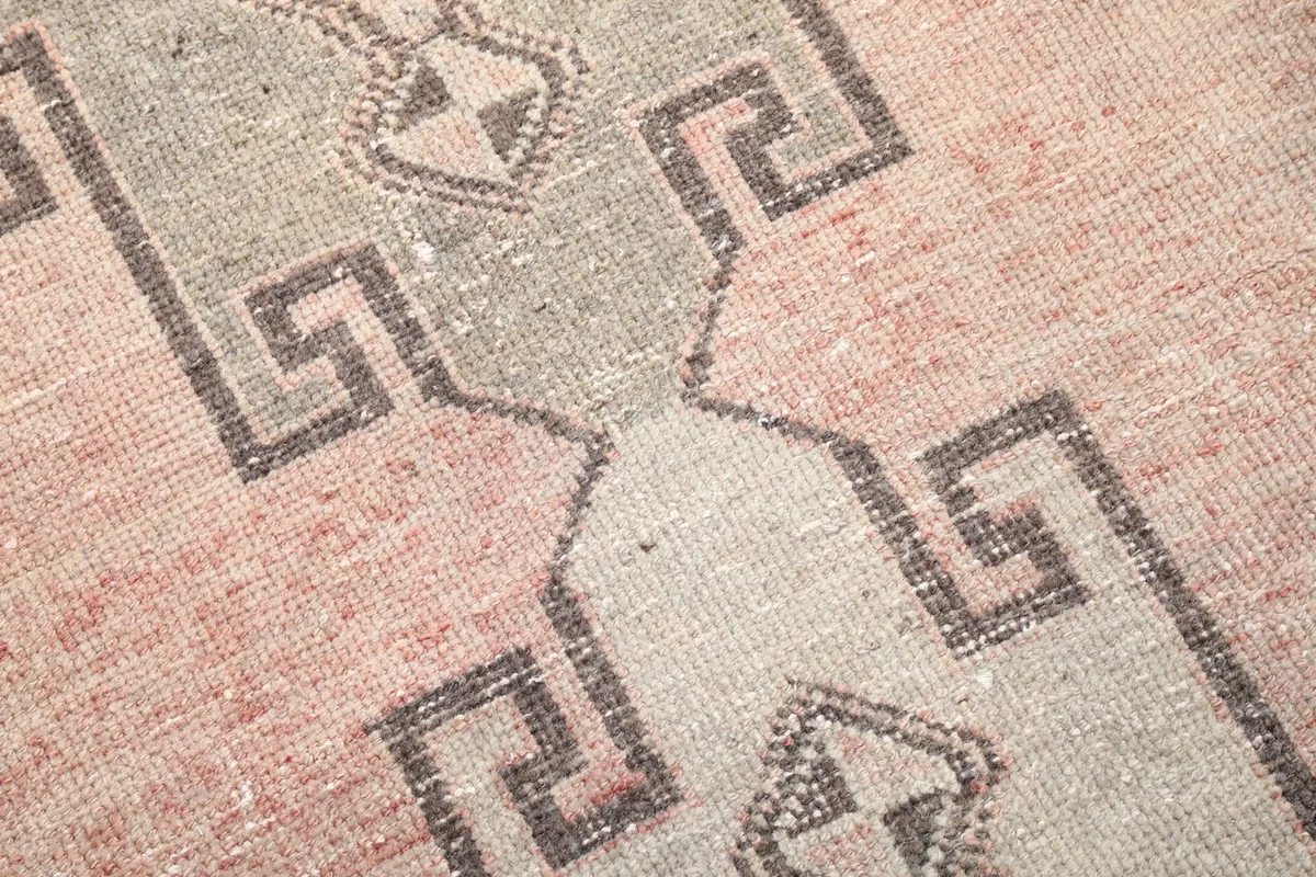 Detailed shot of the low wool pile and the hand-knotted texture of the rug.