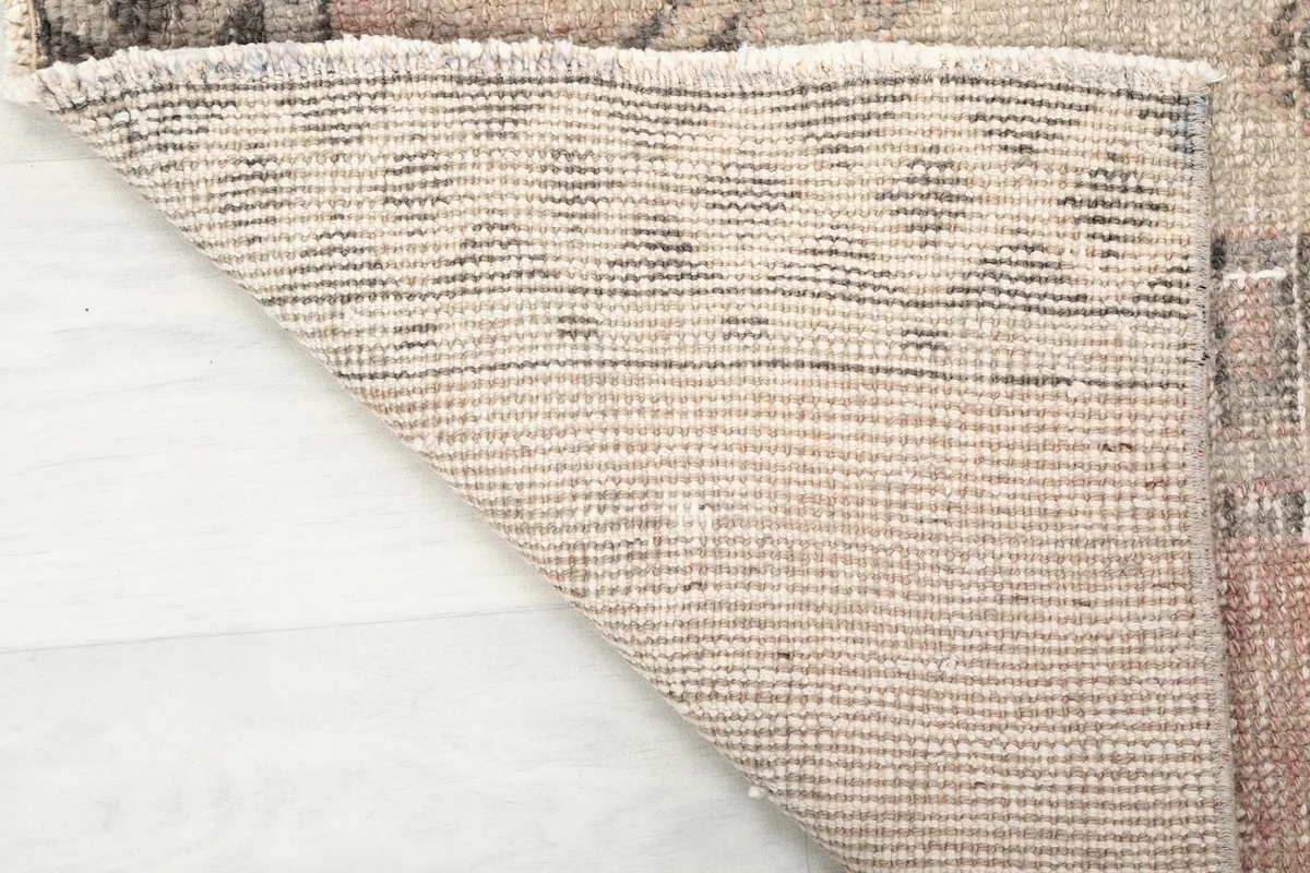 Underside of the hand-knotted wool rug, showing the cotton foundation and construction.