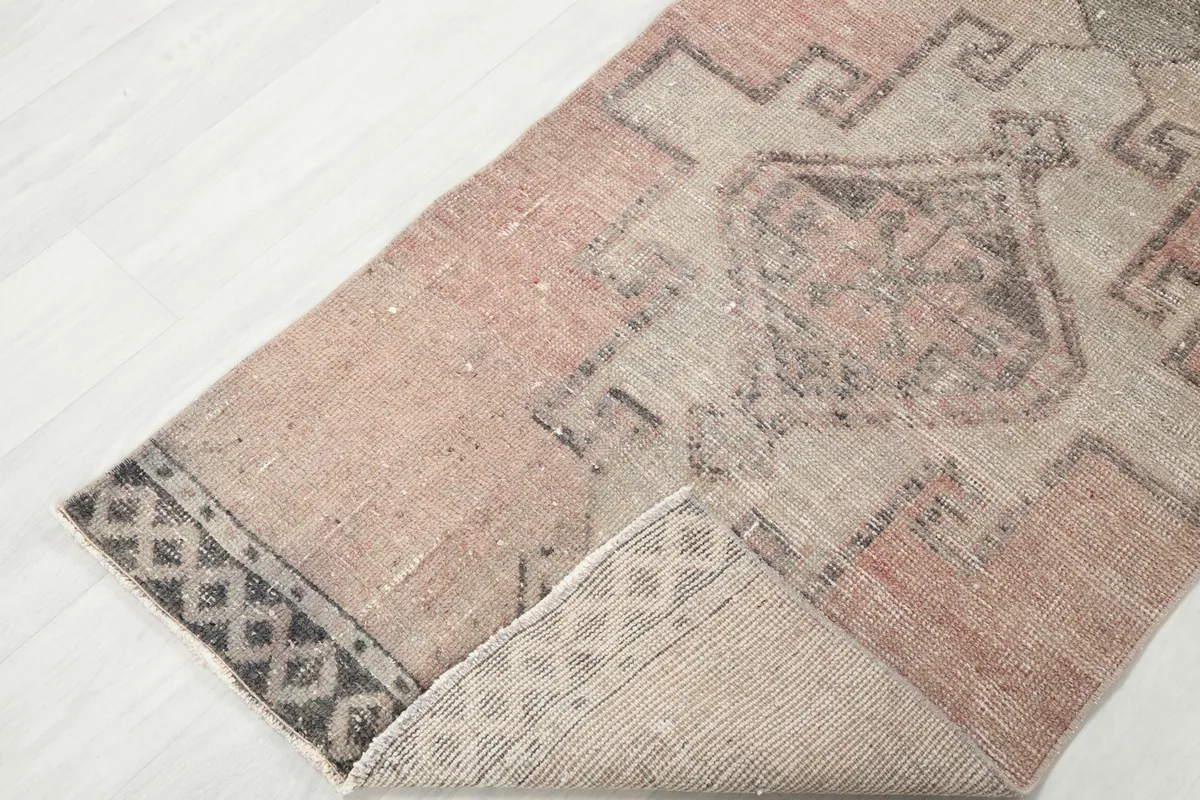 View of the rug folded back slightly, revealing the underside and the integrity of the weave.