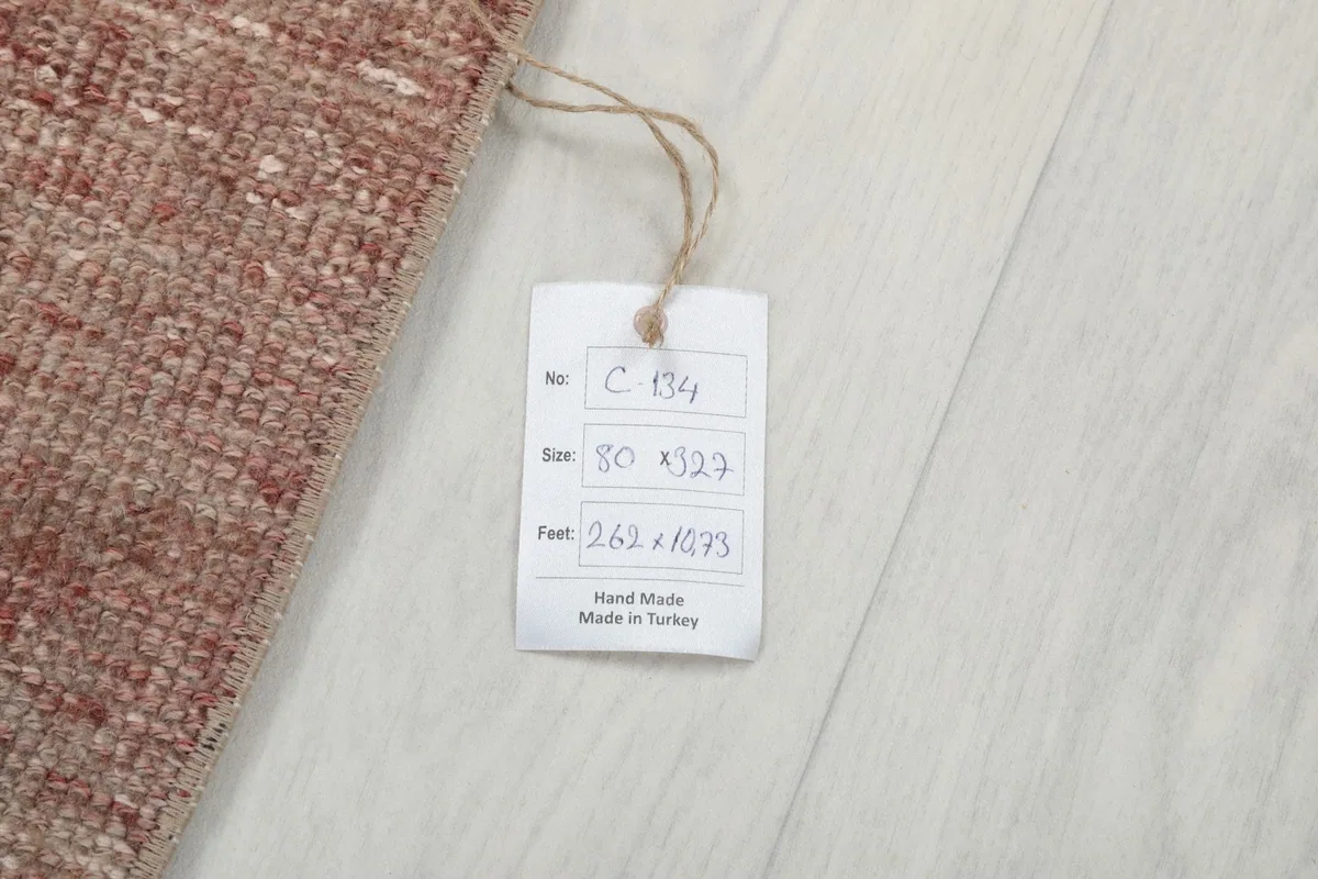 Product tag attached to the rug, displaying its size in centimeters and feet, and origin.