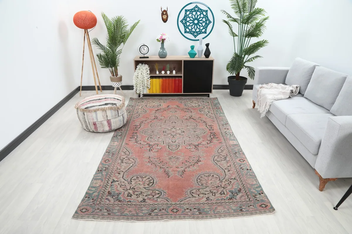Vintage Anatolian rug with rose field and blue border in a modern living room setting