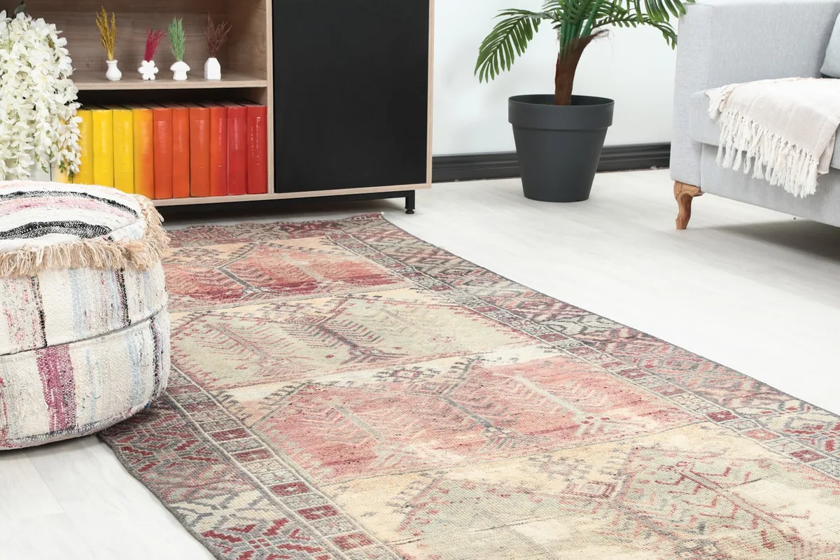 Close-up of the rug's pattern and colors within the room setting, near a decorative ottoman