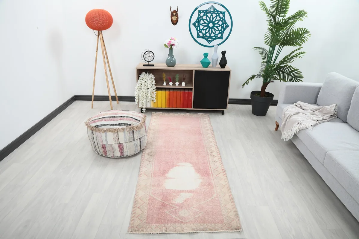Vintage rose pink runner rug displayed in a modern living space, showing its size and color in context.