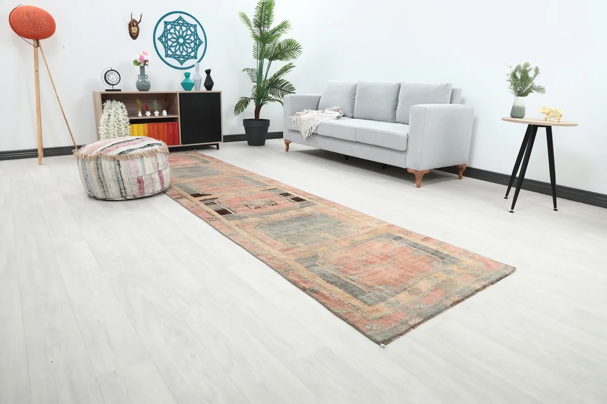 Angled view of the rose and gray runner rug in a room, highlighting its length and design
