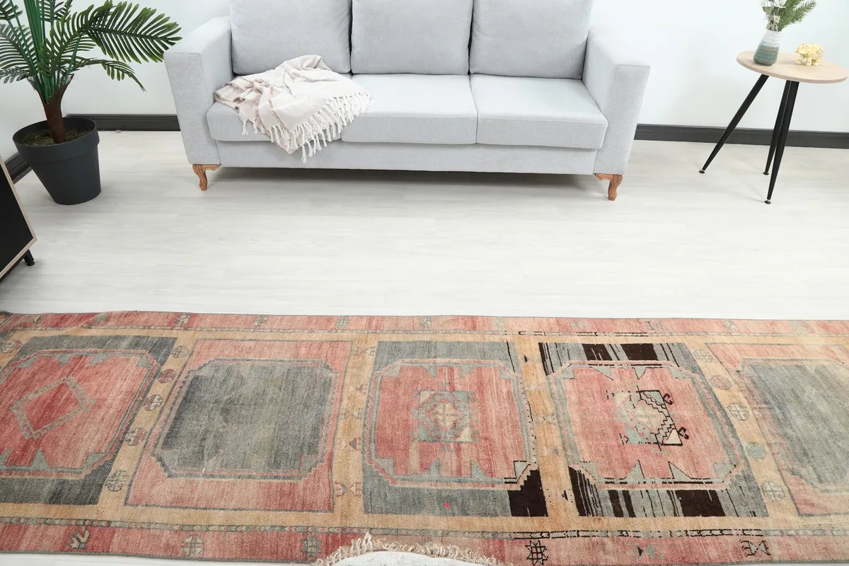 Overhead view showing the distressed rose and gray medallions of the vintage runner rug in a room