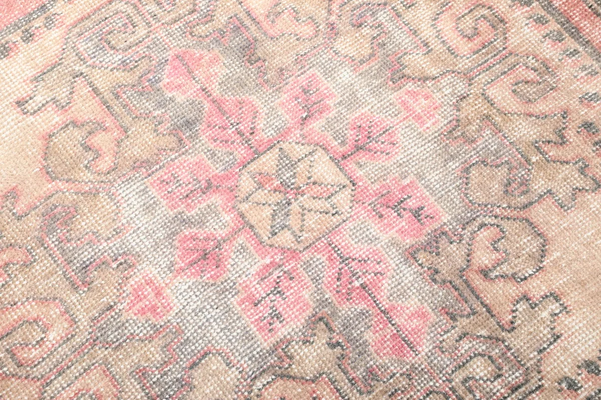 Close-up of the central motif, highlighting the intricate hand-knotted wool pile and color variations.