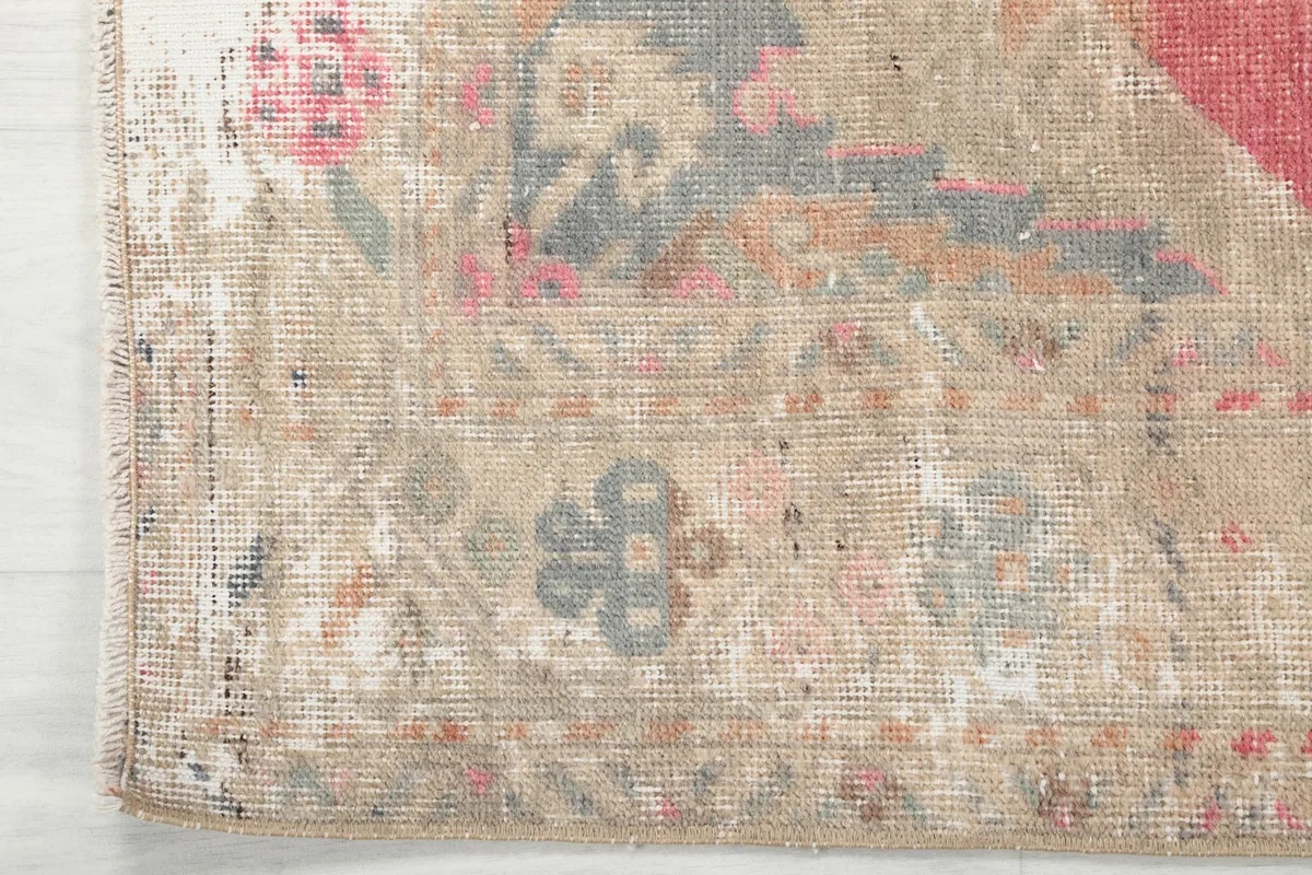 Close-up of the rug's corner and border design, highlighting the distressed wool pile