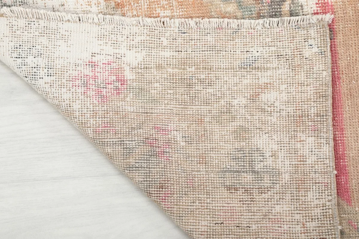 Detailed shot of the rug's hand-knotted cotton foundation and the reverse side of the wool pile