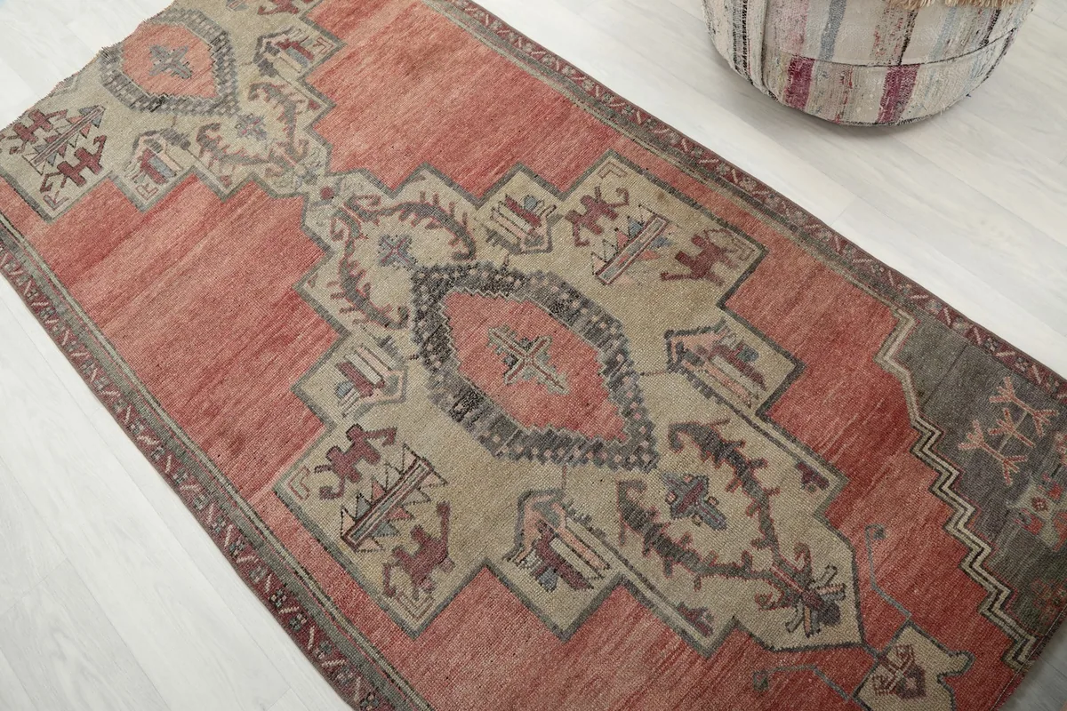 Angled view of the rose and beige rug's surface, capturing the texture and color variations