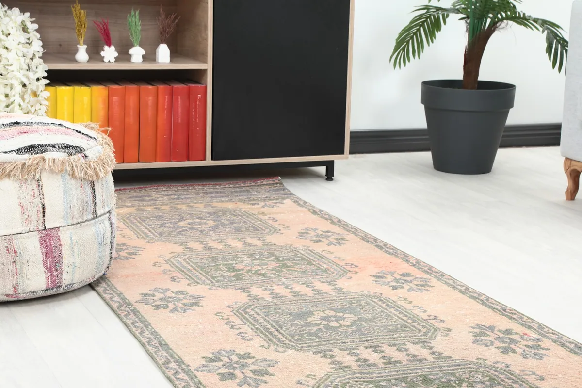 Close-up of the runner rug in a room setting, showing geometric patterns near a decorative pouf.
