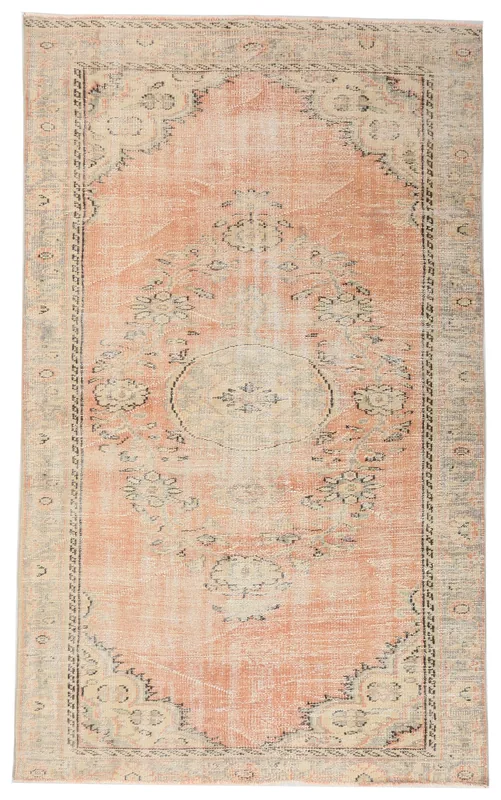 Full overhead view of the orange floral medallion vintage Anatolian rug on a white background