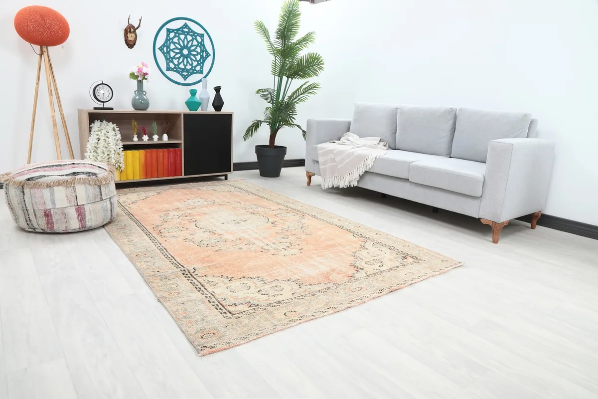 Angled view of the orange vintage rug in a living space, highlighting its placement and colors