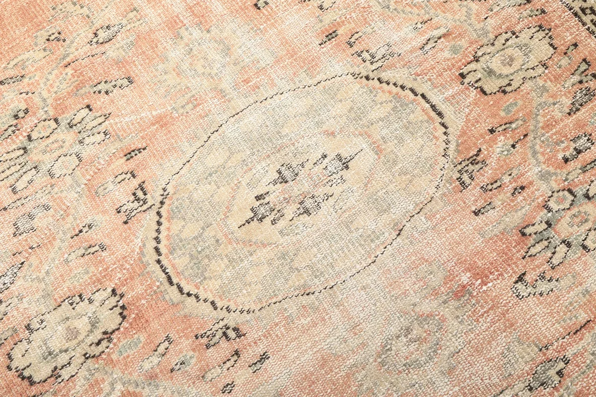 Intricate detail of the central medallion design with beige and charcoal accents