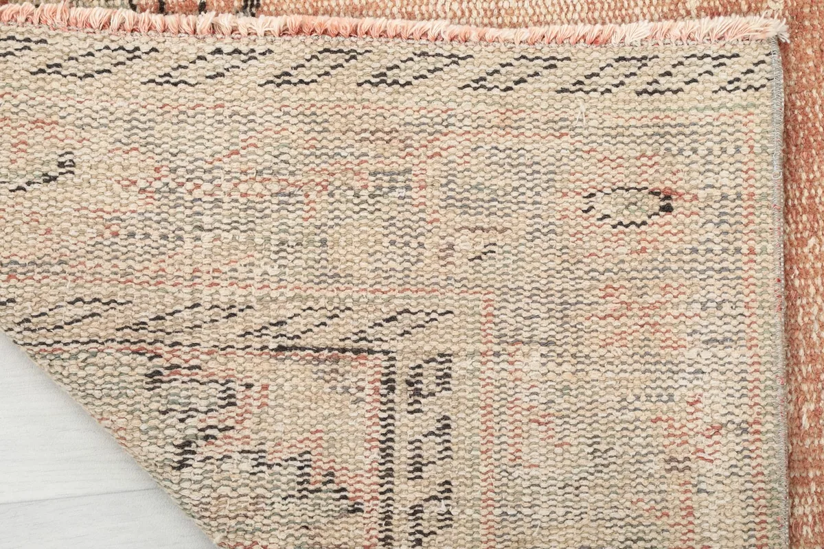 Reverse side of the hand-knotted rug, revealing the cotton foundation and knot structure
