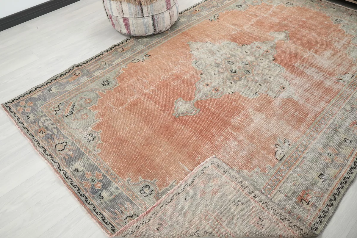 View of the rug folded back to show the reverse side and the hand-knotted cotton foundation