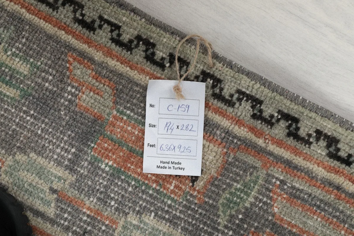 Tag showing the rug's size in feet (6'4" x 9'3") and centimeters, confirming origin and material