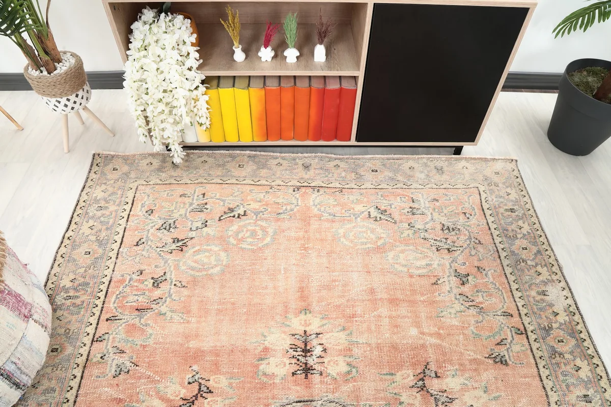 Detail of the upper section of the rose rug, showing floral motifs and the distressed border