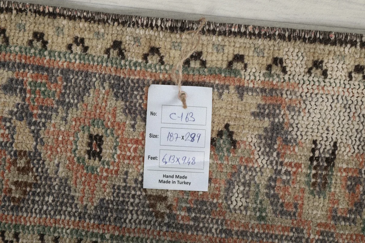 Close-up of the back of the rug with a tag indicating origin, size, and hand-knotted craftsmanship