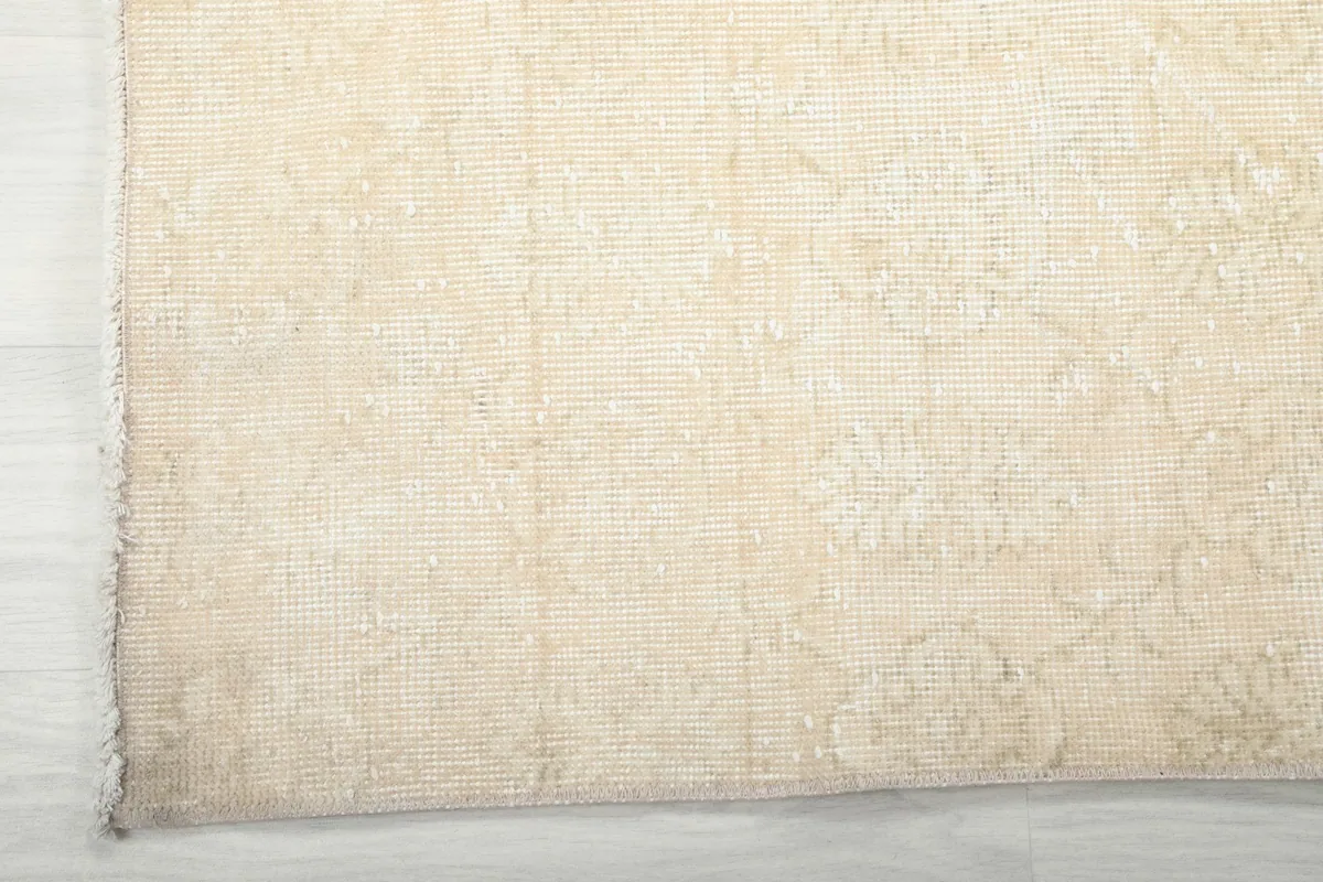 Corner detail showing the low pile and the faint floral motifs on the vintage rug