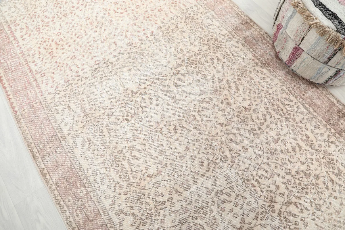 Diagonal view of the rug's surface, revealing the subtle floral motifs and patina