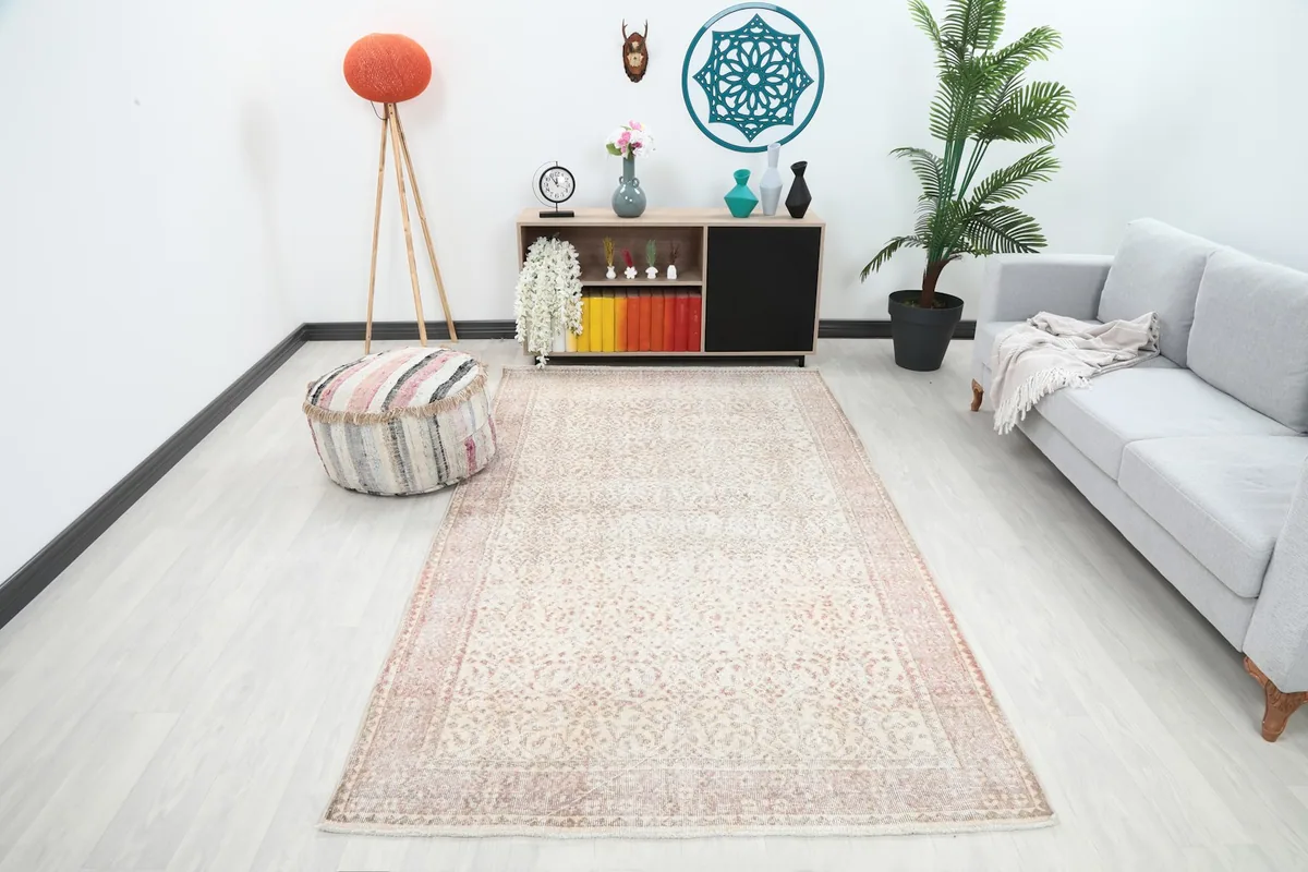 Vintage Anatolian rug in a modern living room setting with a gray sofa and wooden cabinet