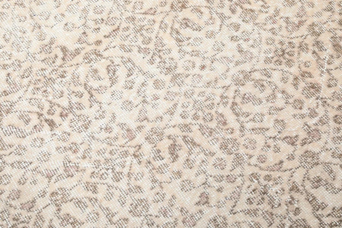 Detailed close-up of the ivory field with tan and rose floral patterns