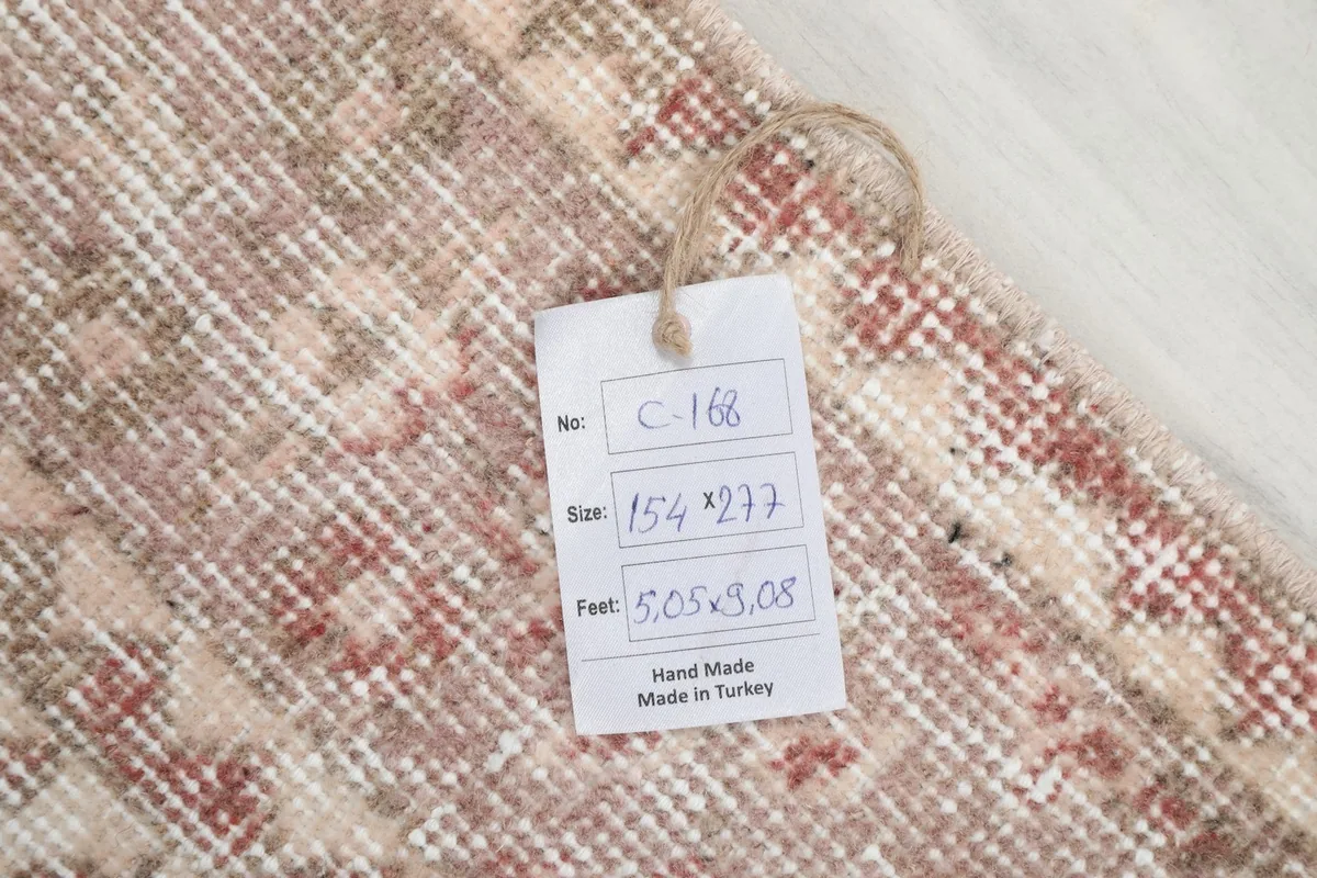 Tag showing the rug's dimensions and origin, placed on the hand-knotted surface