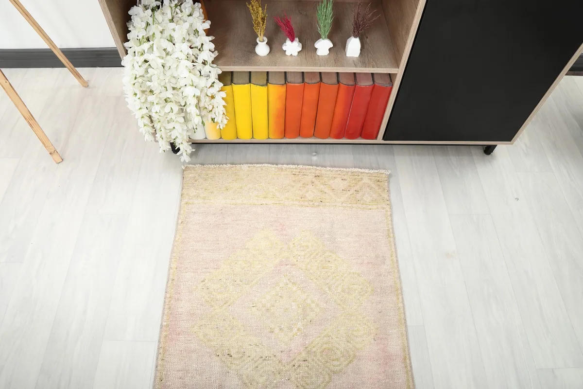 Top-down view of the runner rug's end, highlighting its faded geometric patterns