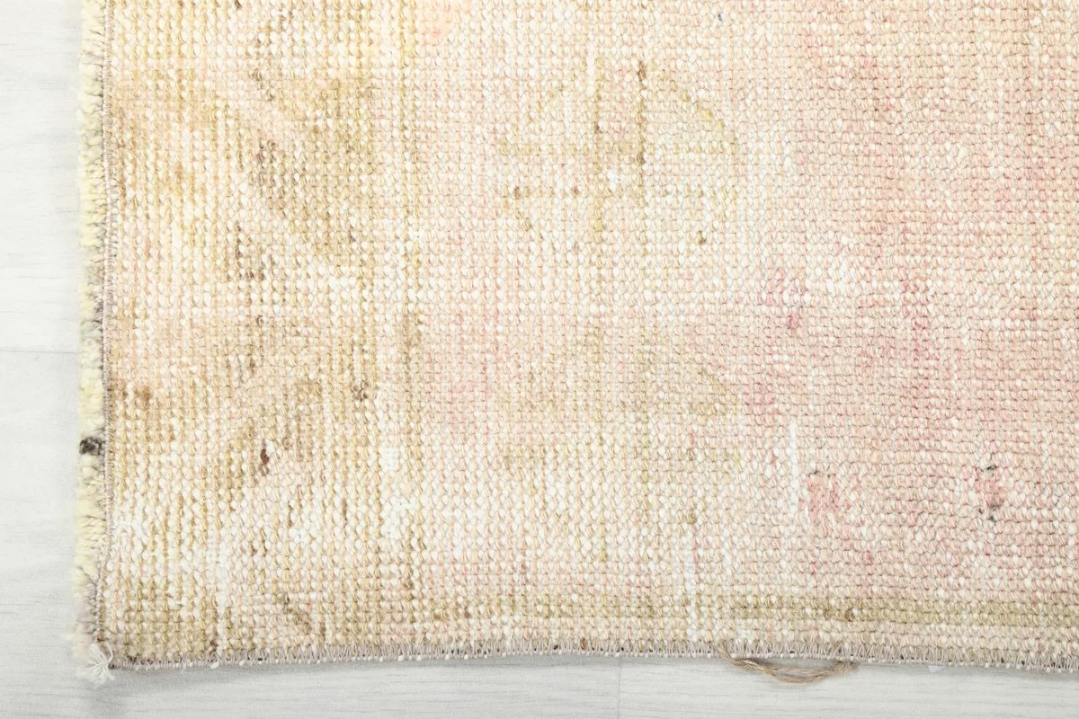 Corner detail of the rug, showing the edge finish and the tightly woven wool pile