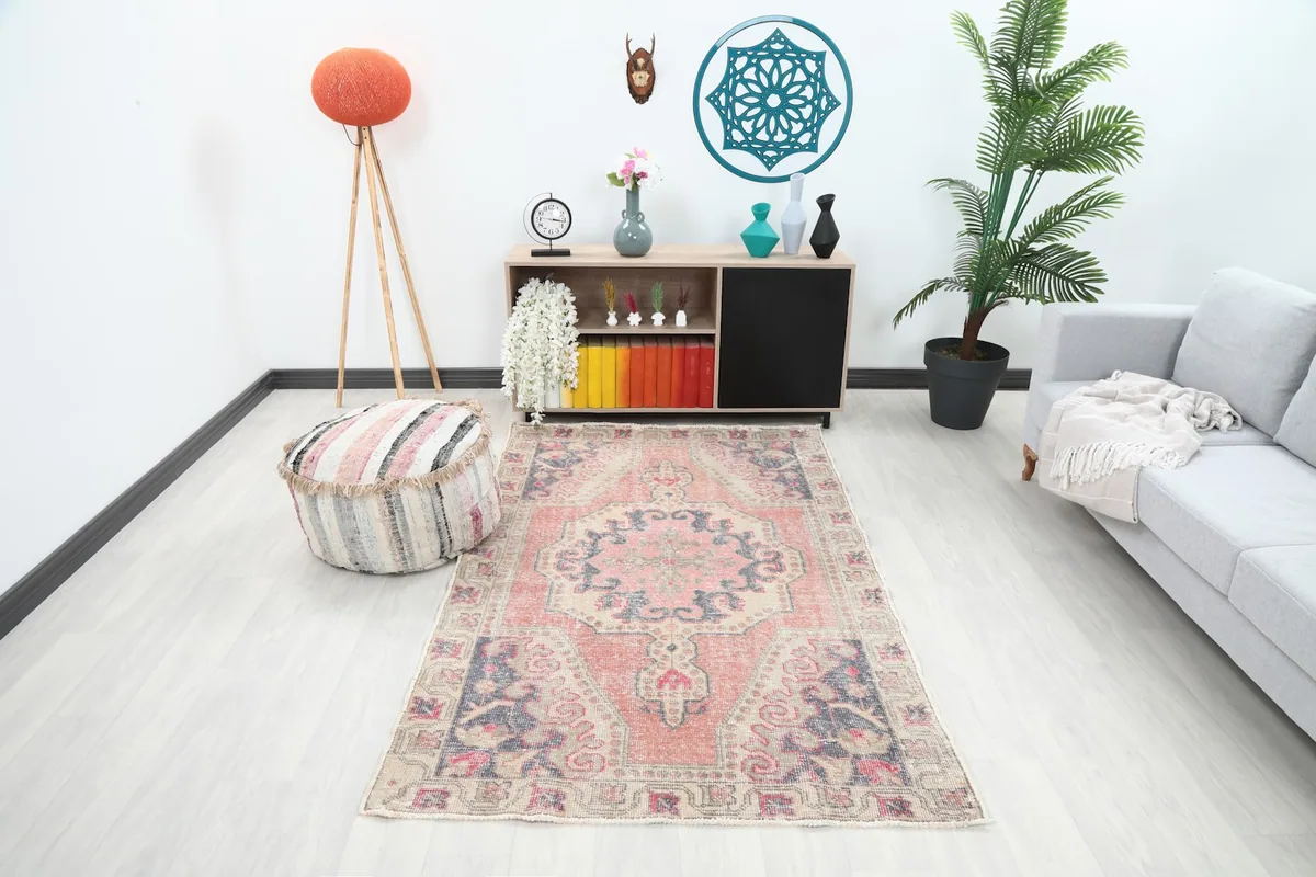 Vintage Anatolian rug with rose and navy tones placed in a modern living room setting