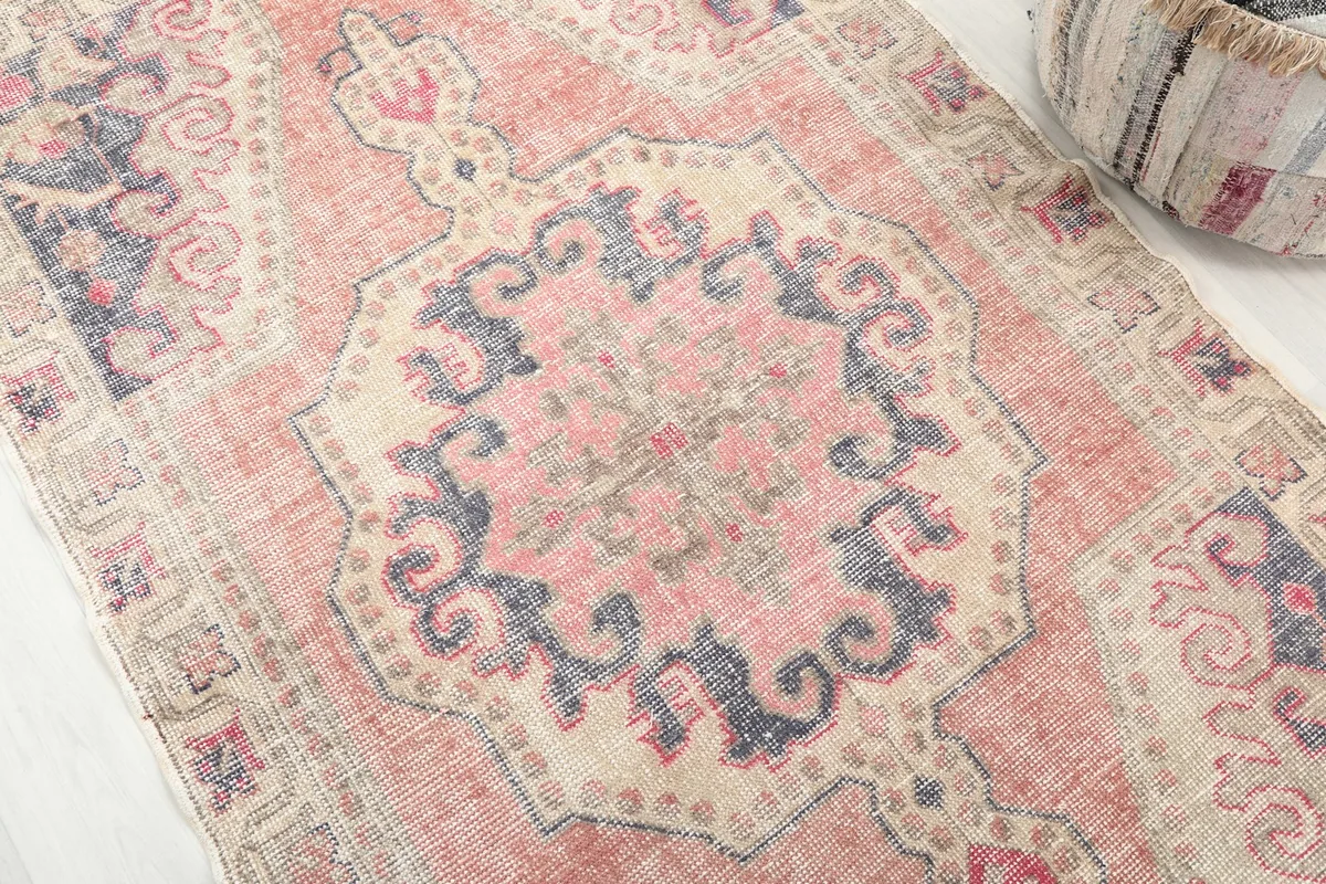 Detailed view of the central rose and navy medallion motif on the vintage rug