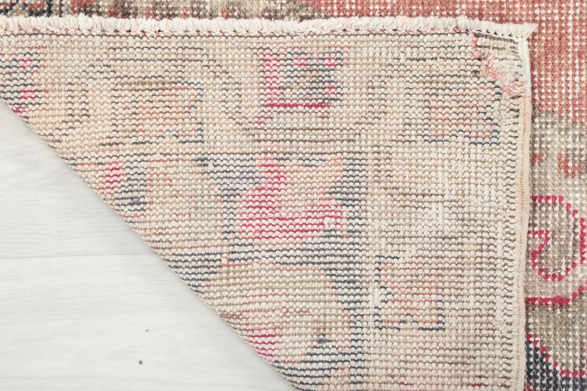 Underside view of the hand-knotted rug, revealing the cotton foundation and knotting