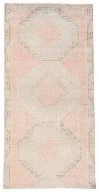 Full overhead view of the rose and beige geometric vintage Anatolian runner rug on a white background.