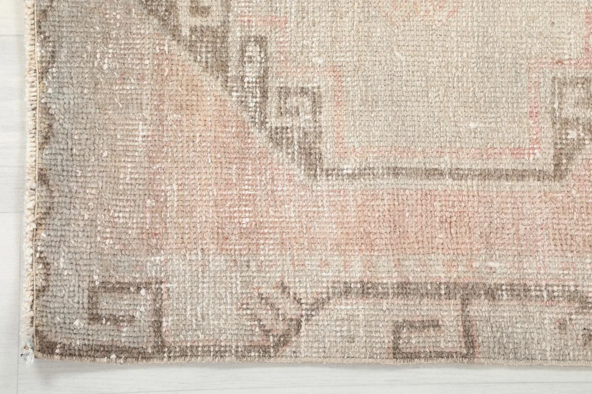 Close-up of the rug's border showing the tribal-inspired geometric design in gray and beige.