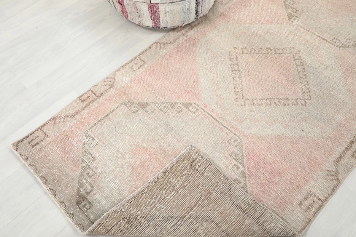 Corner of the Anatolian runner folded to reveal the wool pile and cotton foundation.