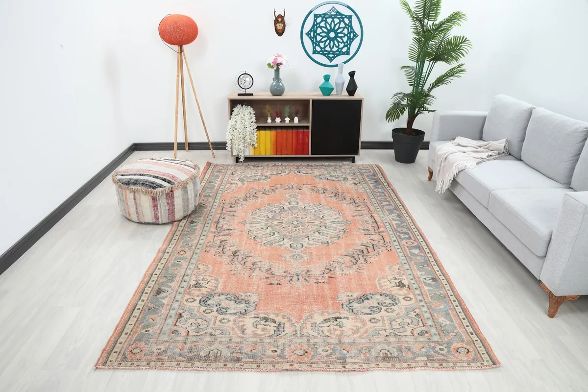 Orange vintage rug in a modern living room setting with a gray sofa