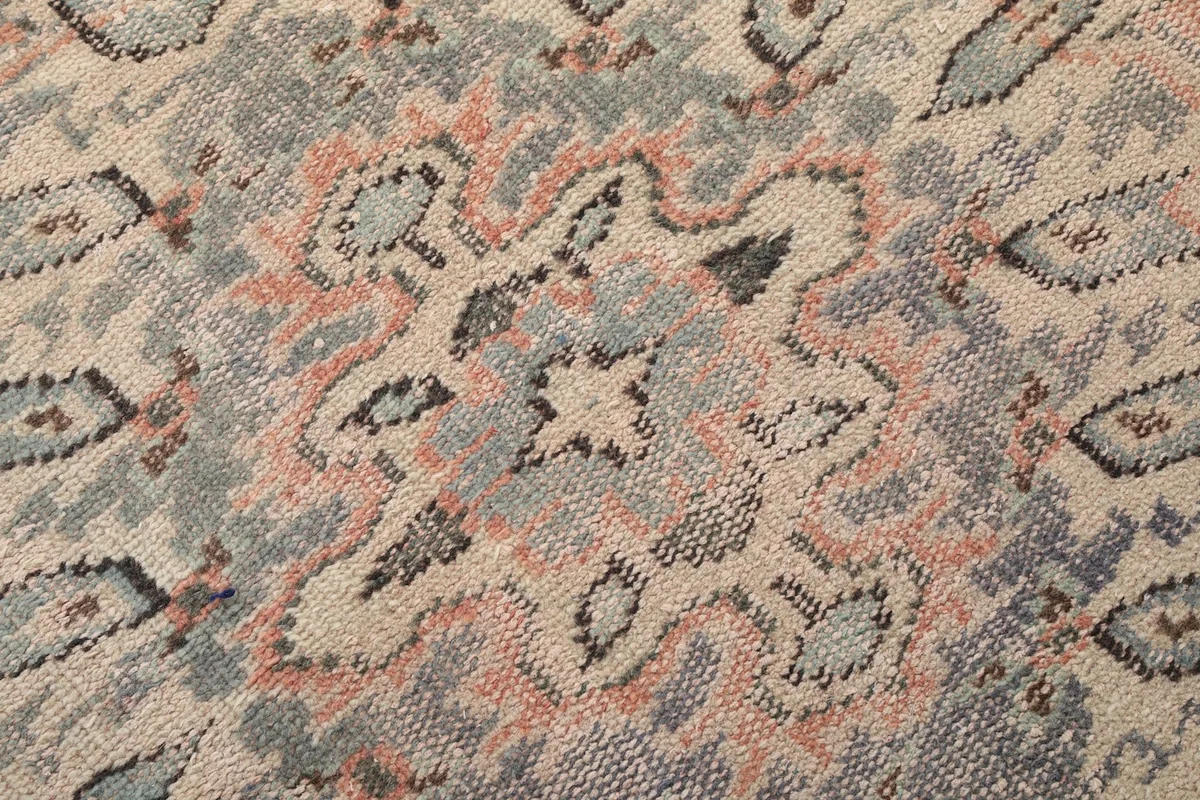 Close-up of the intricate patterns and aged wool pile texture on the vintage rug