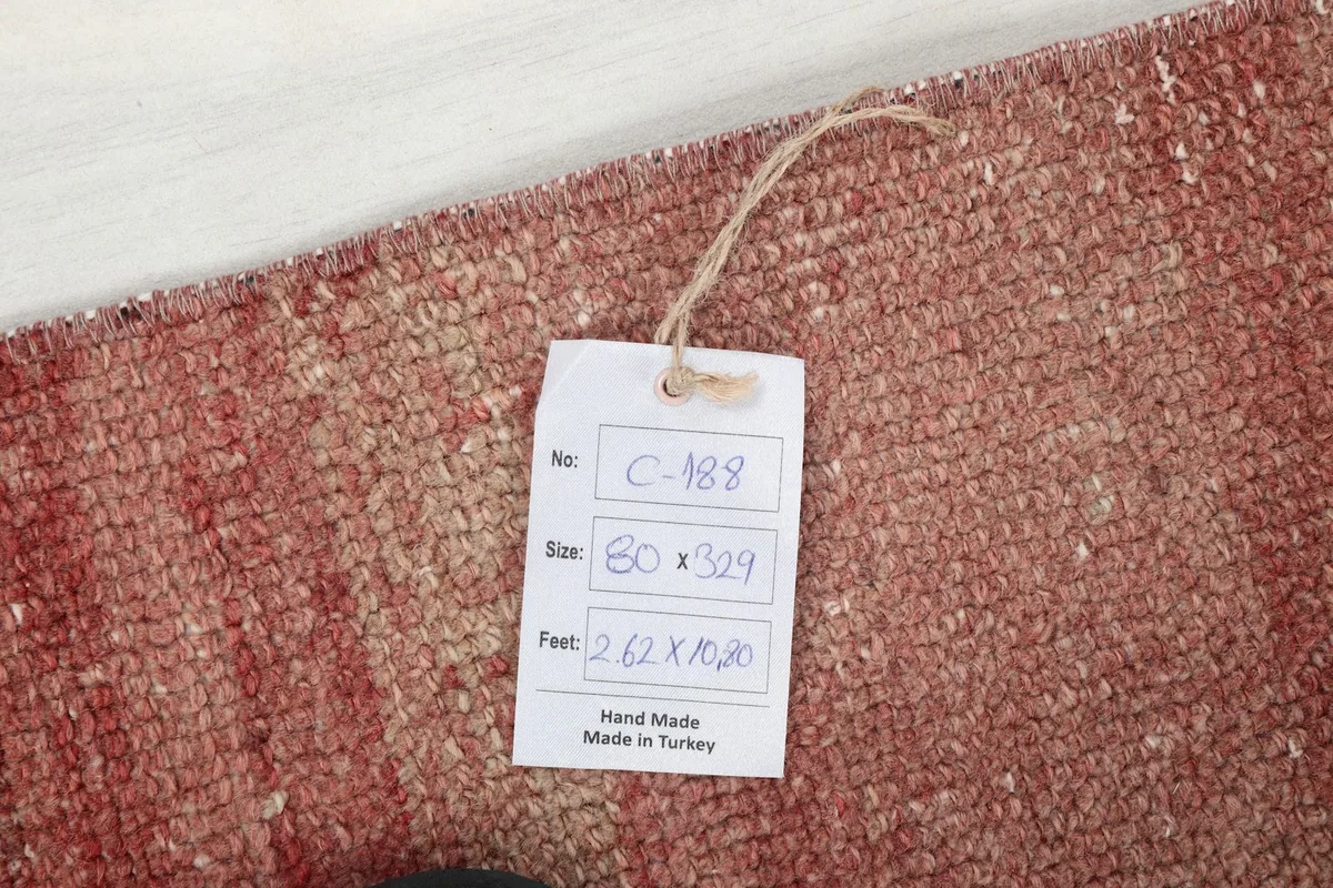 Product tag showing the rug's dimensions and hand-made origin on the rose pile
