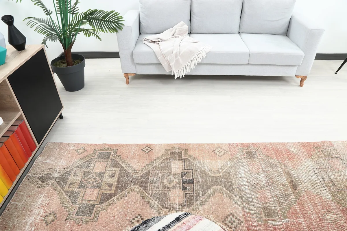 Overhead view of the vintage runner rug in a room, showing its length and placement relative to a sofa.
