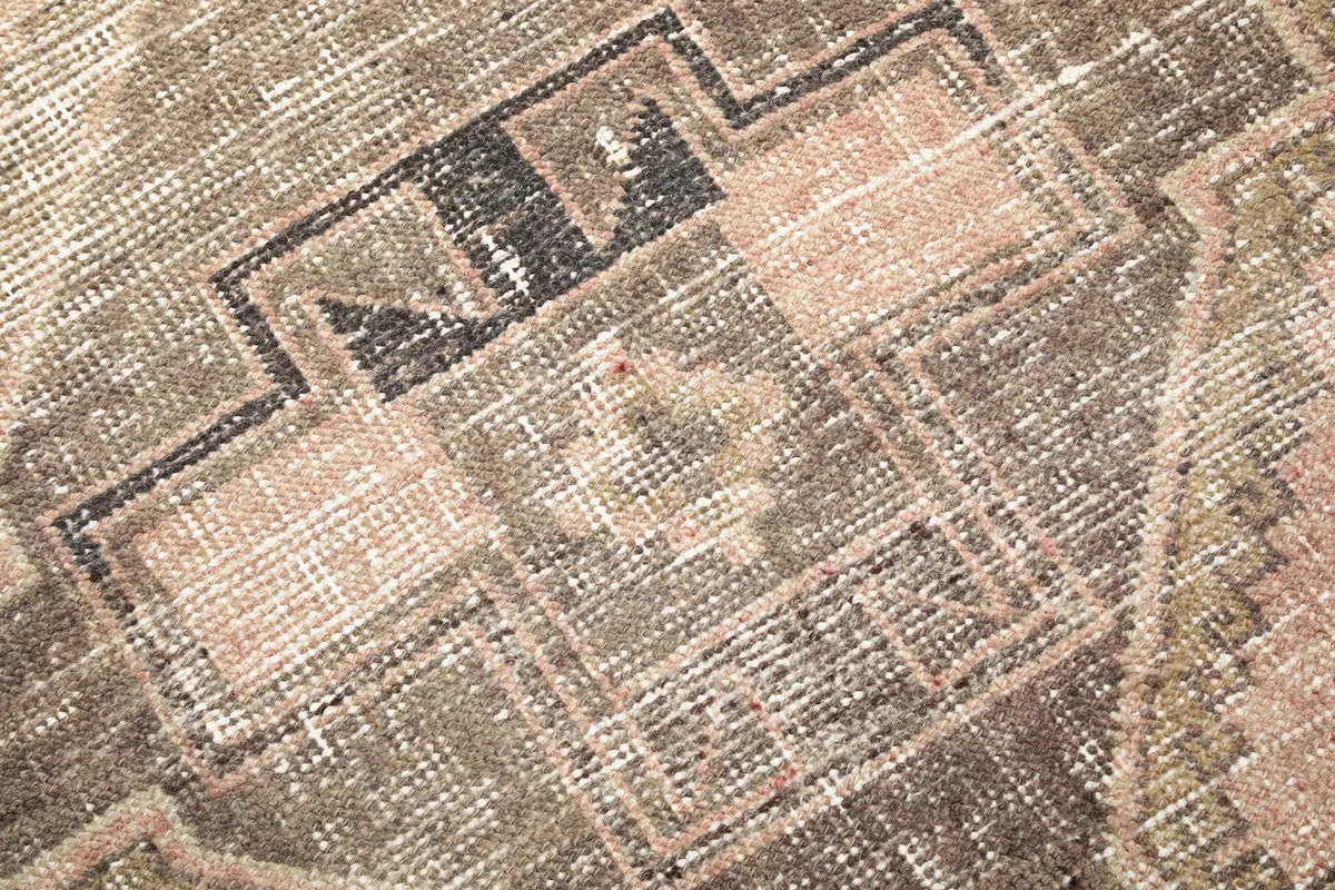 Detailed view of the hand-knotted wool pile, showing texture and color variations within a geometric pattern.